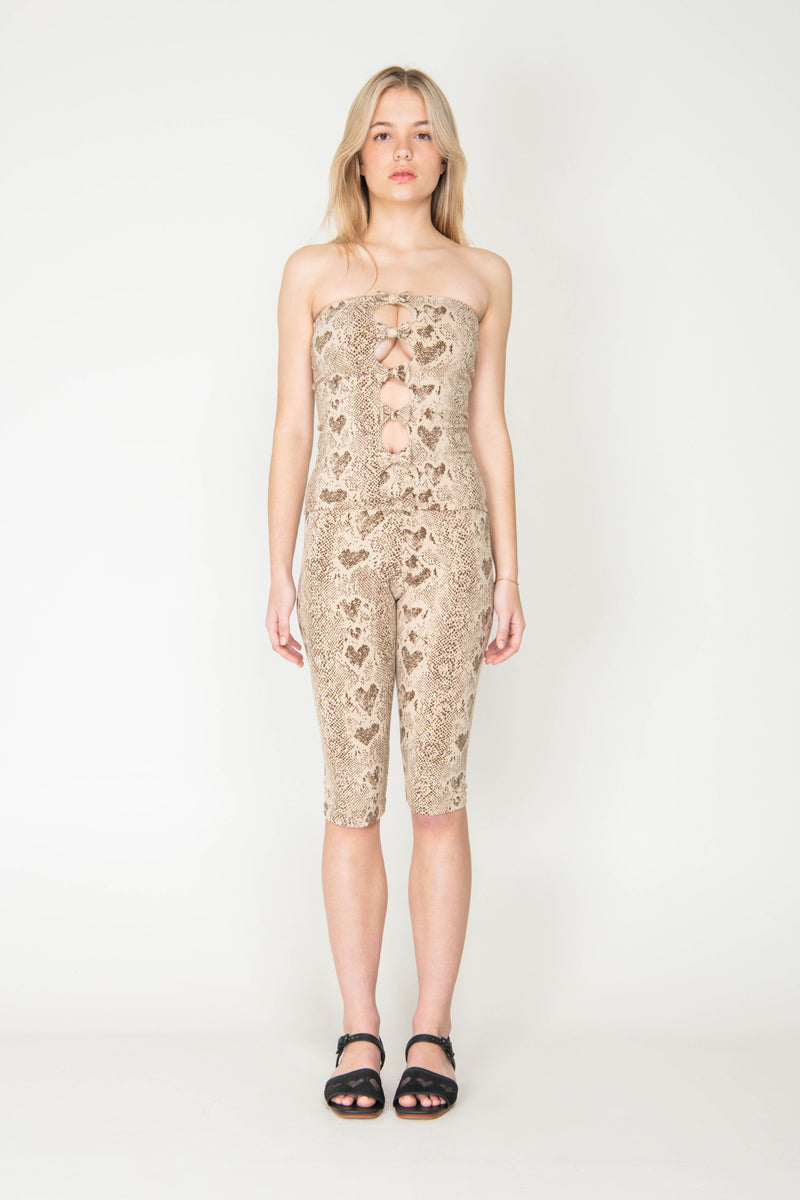 Woman wearing a strapless jumpsuit with heart pattern on a white background