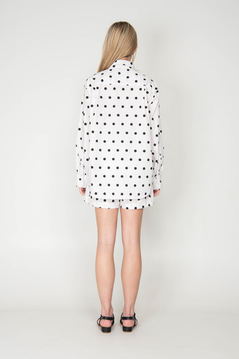 Person wearing a polka dot outfit on a plain background