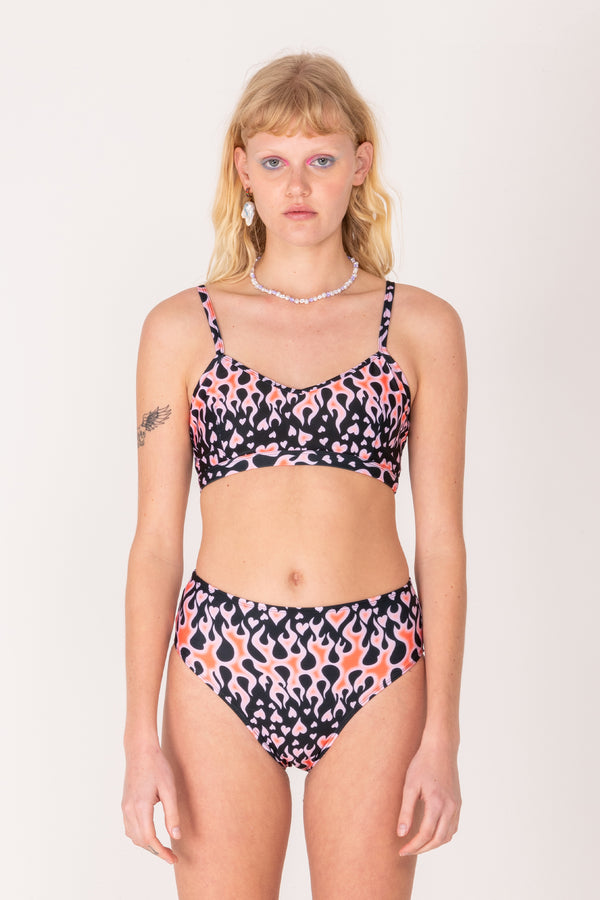 Woman wearing a patterned bikini set on a plain background