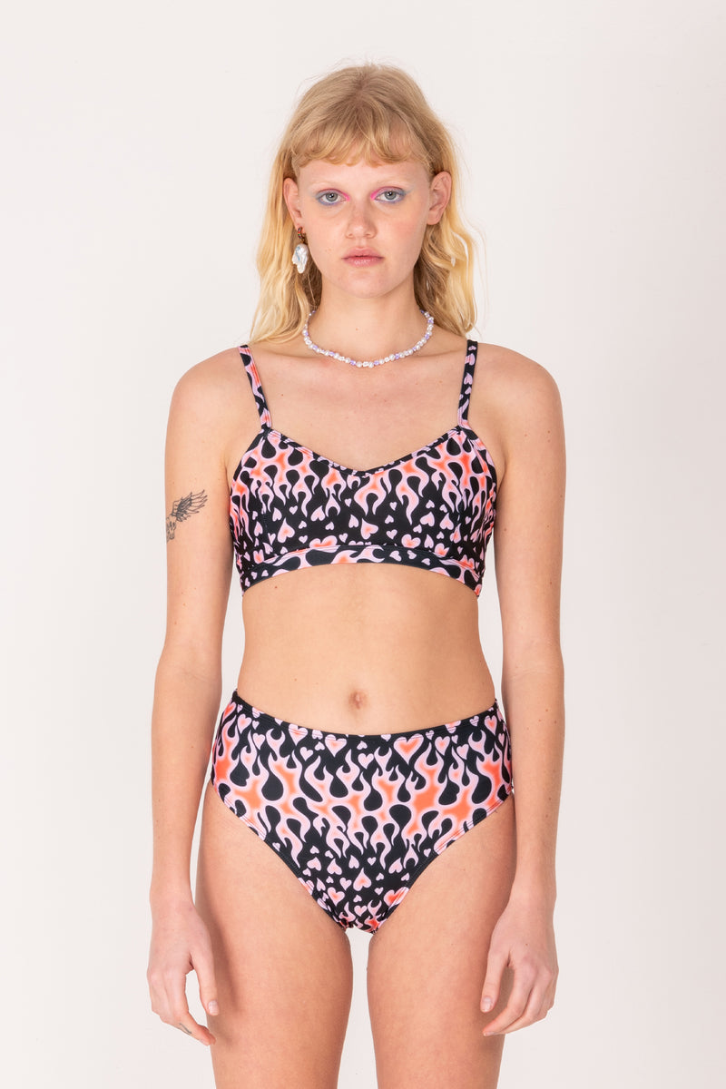 Woman wearing a patterned bikini set on a plain background