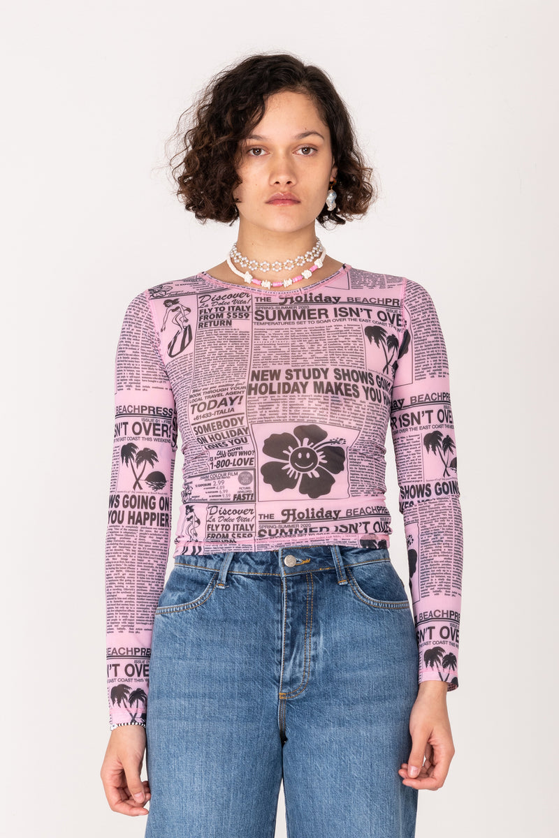 Person wearing a patterned long-sleeve shirt and jeans on a white background