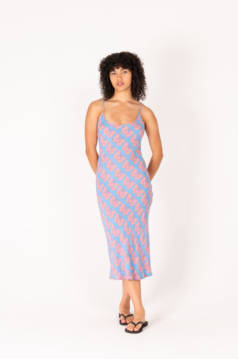 Woman wearing a pink and blue patterned slip dress on a white background
