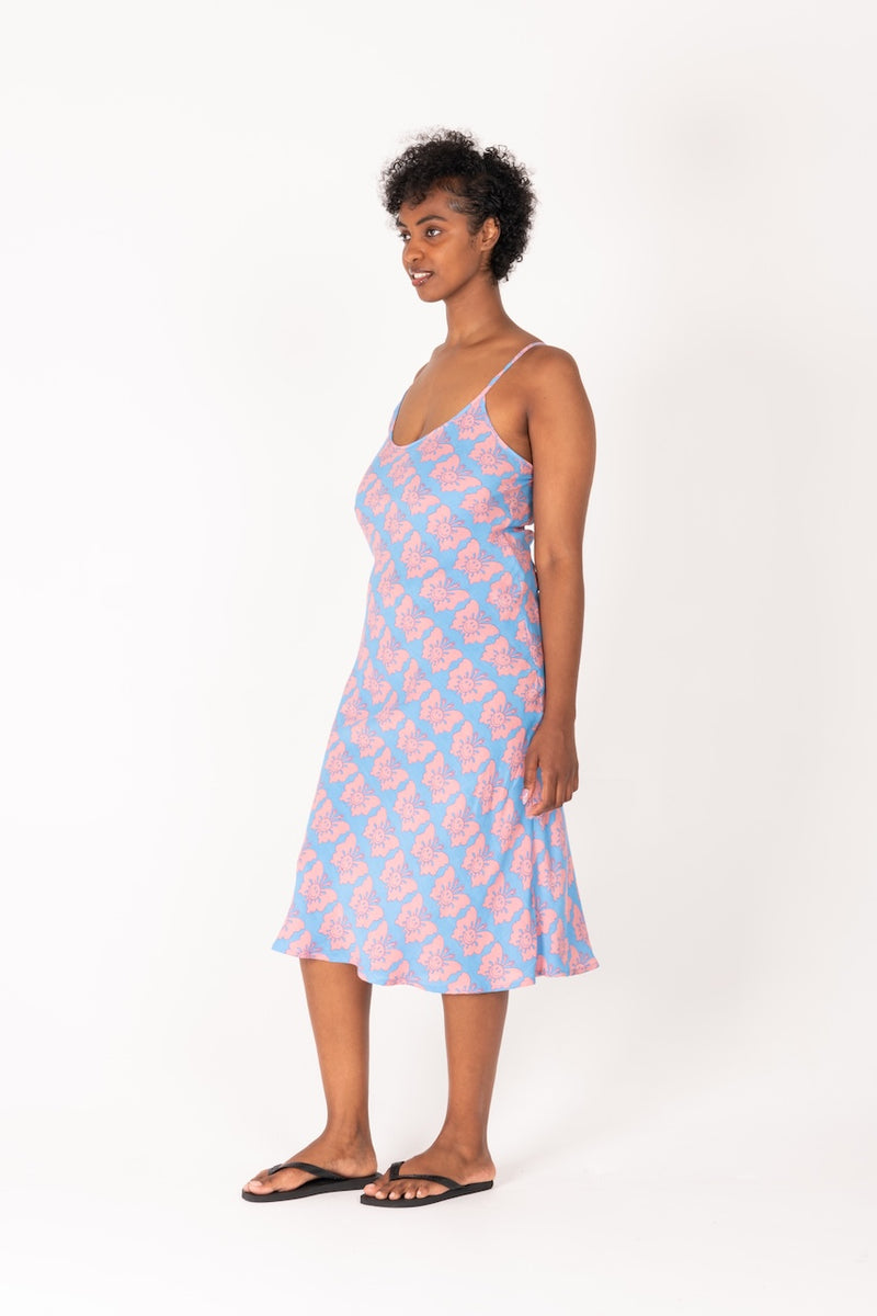 Woman wearing a pink and blue patterned slip dress on a white background