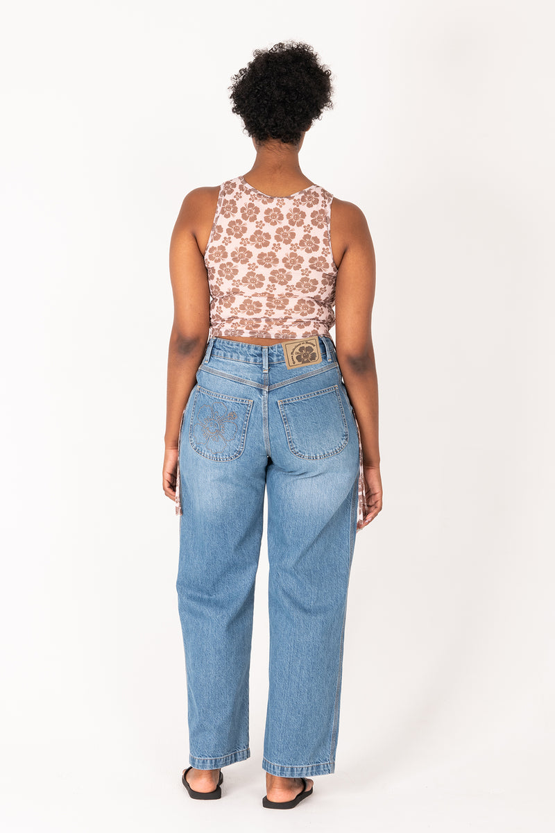 Person wearing a floral top and blue jeans on a white background