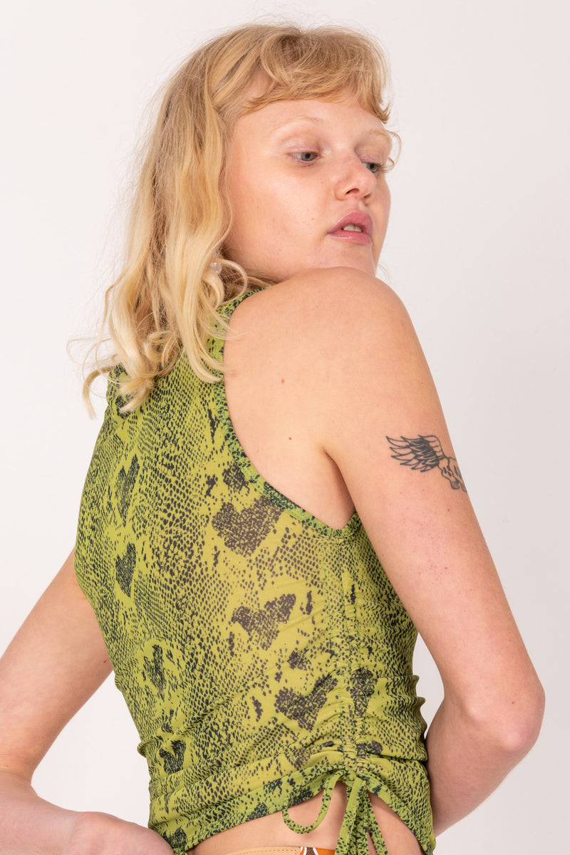 Woman wearing a green patterned top against a white background