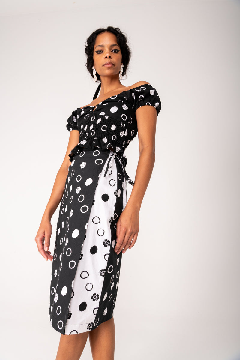 Woman wearing a black and white patterned dress on a plain background