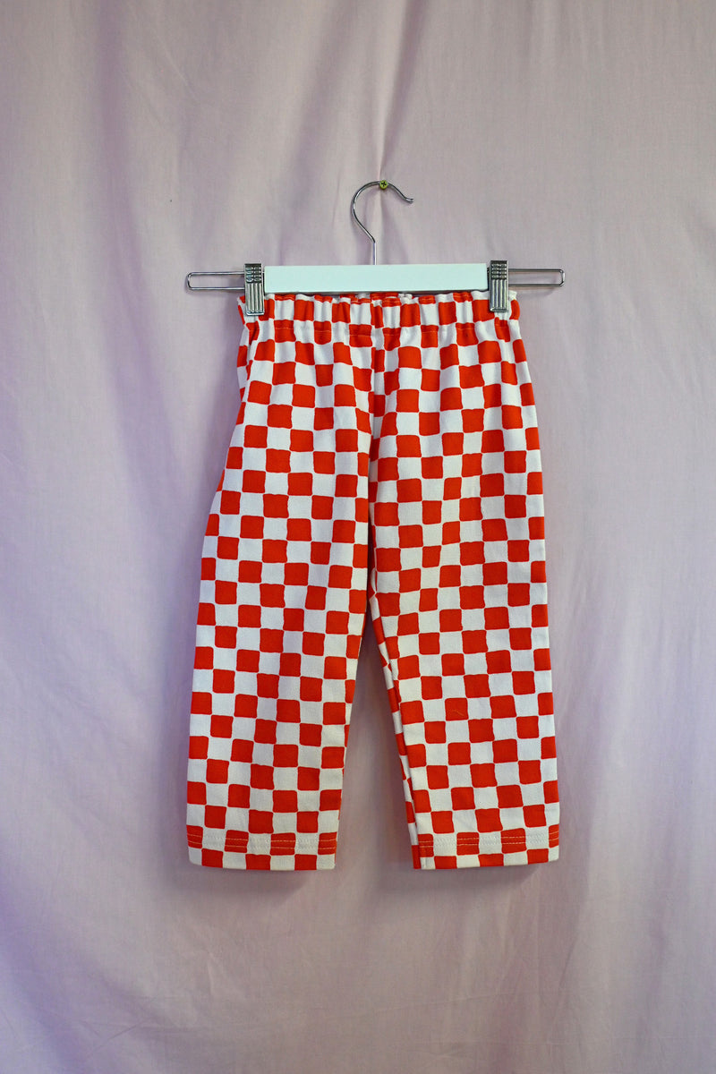 Red and white checkered pants on a hanger against a white background