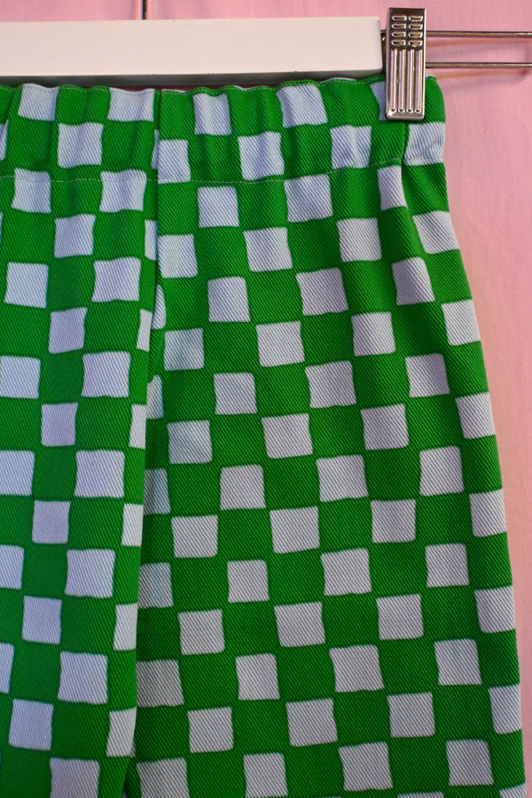 Green and white checkered fabric on a pink background
