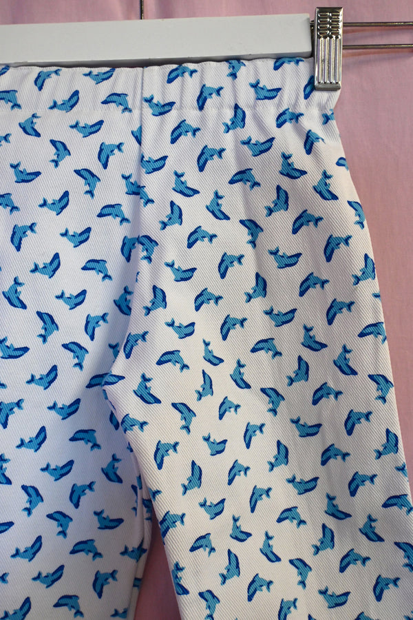 White fabric with blue dolphin pattern on a pink background