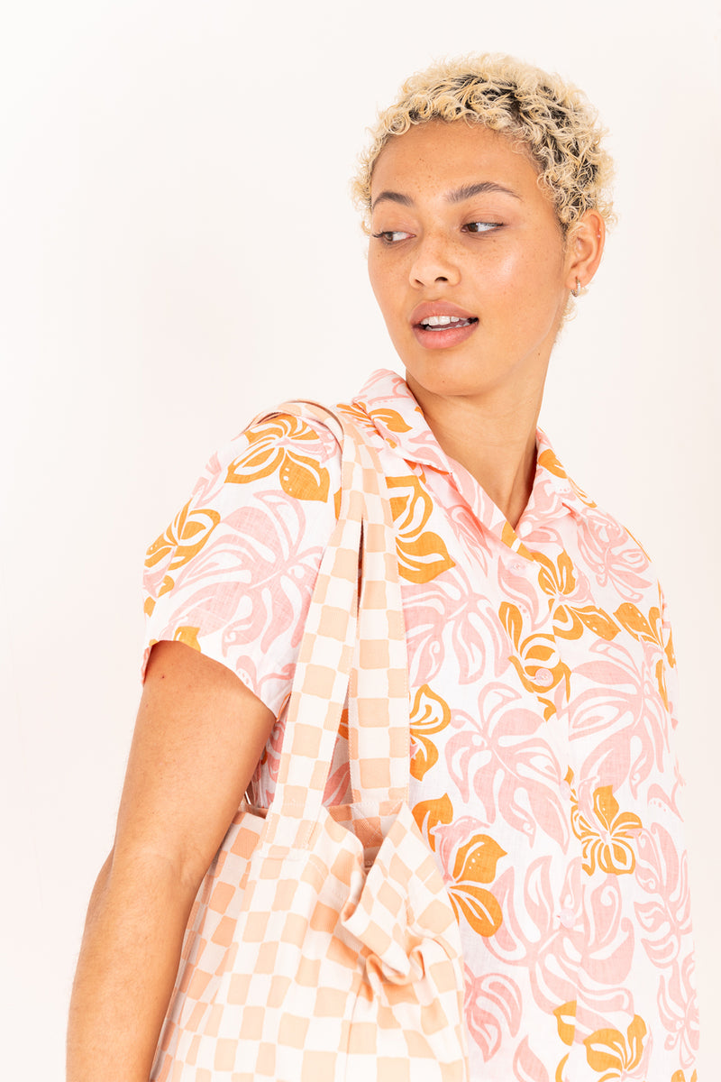 Woman wearing a floral patterned outfit with a white background