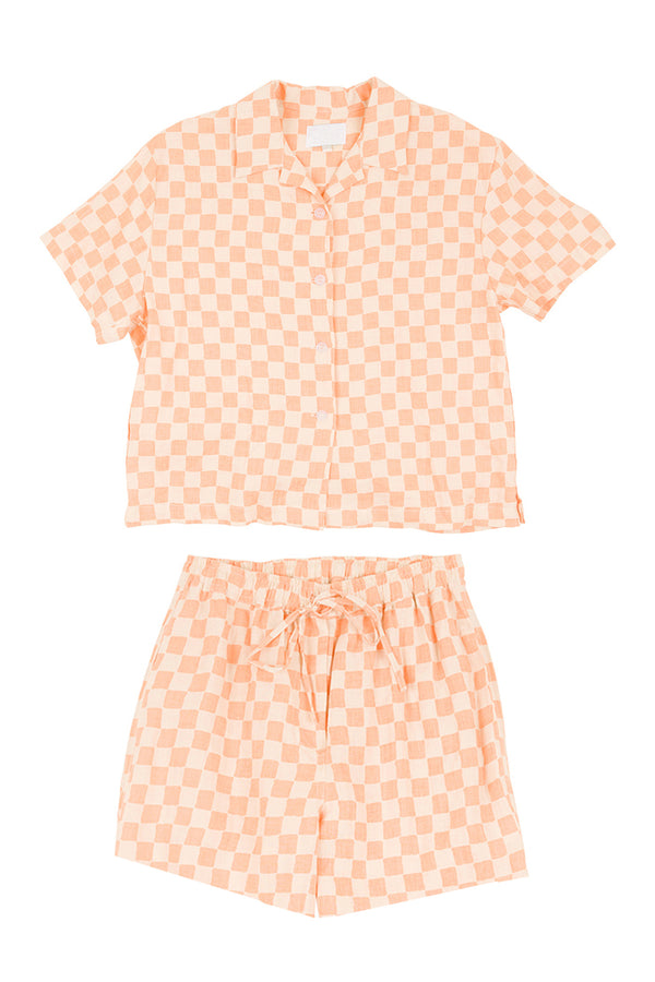 Peach-colored checkered shirt and shorts set on a white background