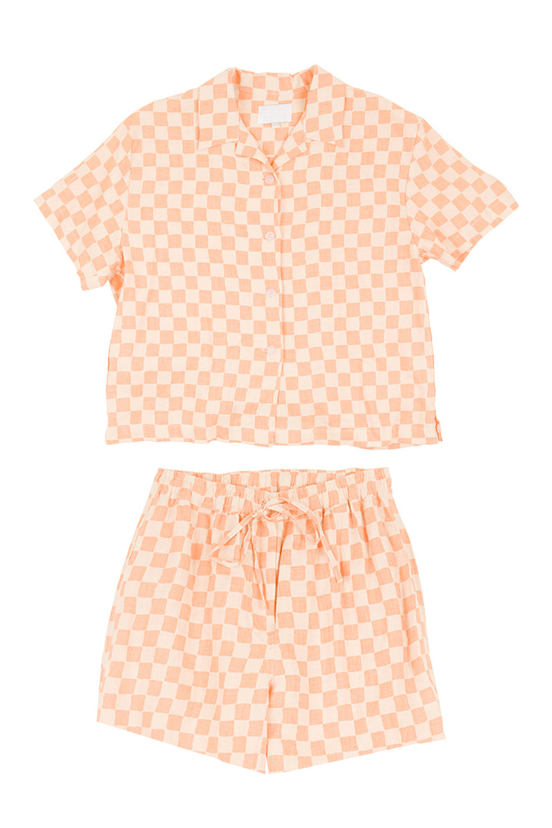 Peach-colored checkered shirt and shorts set on a white background