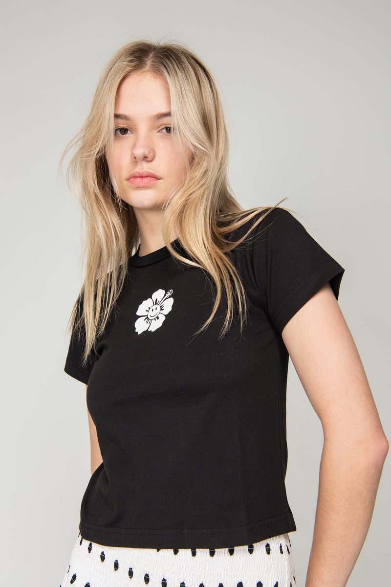 Woman wearing a black t-shirt with a white logo on a plain background