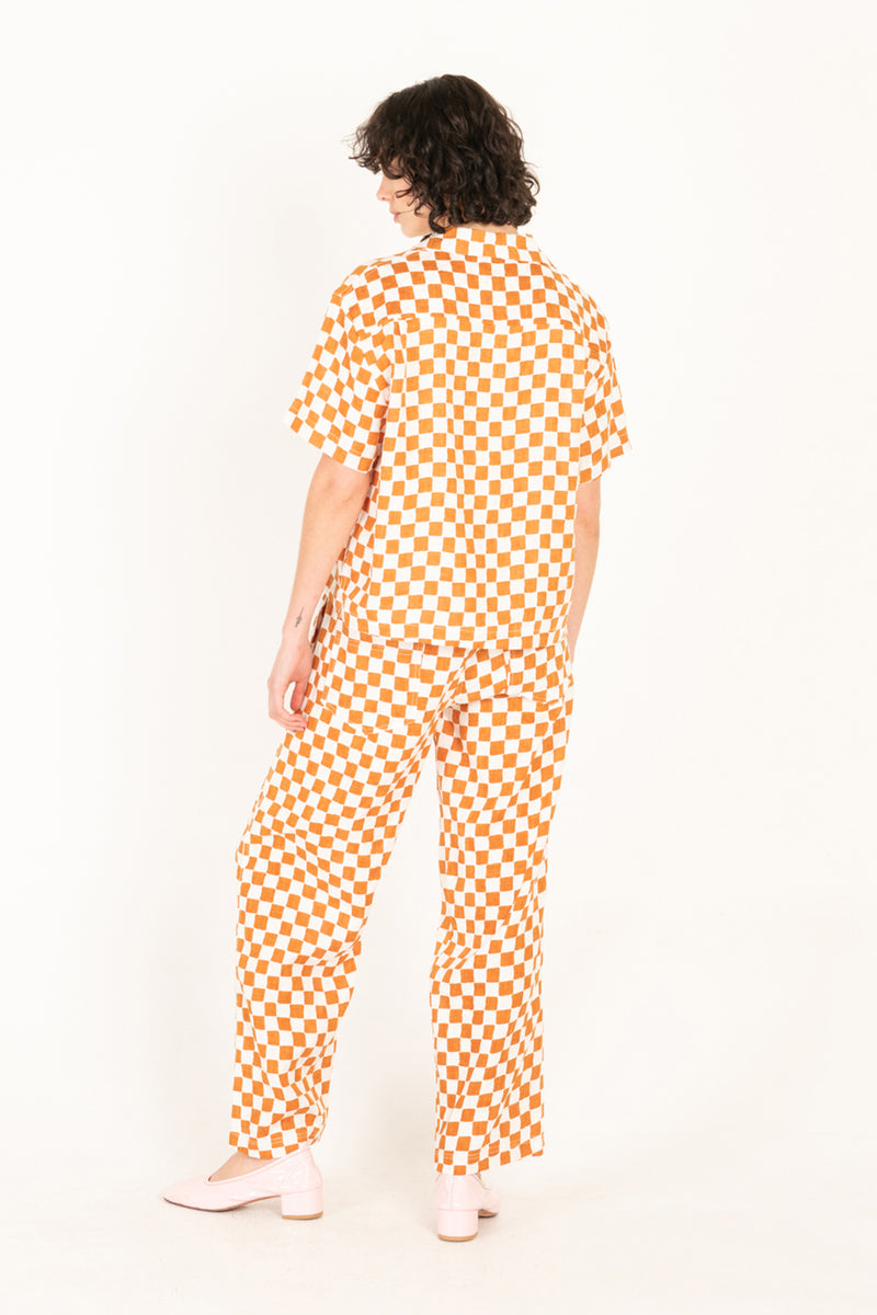 Person wearing a checkered orange and white outfit on a white background