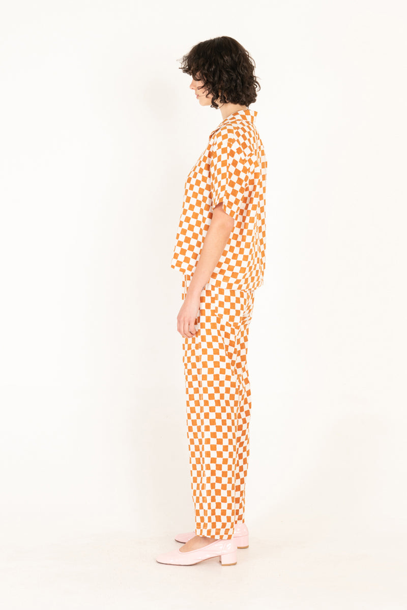 Person wearing a checkered orange and white outfit on a white background