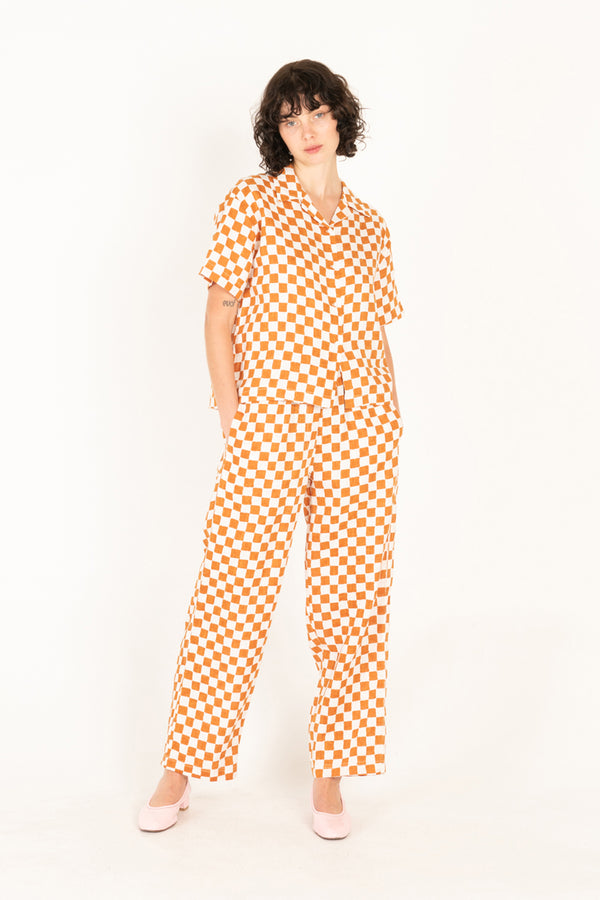 Person wearing an orange and white checkered outfit on a white background