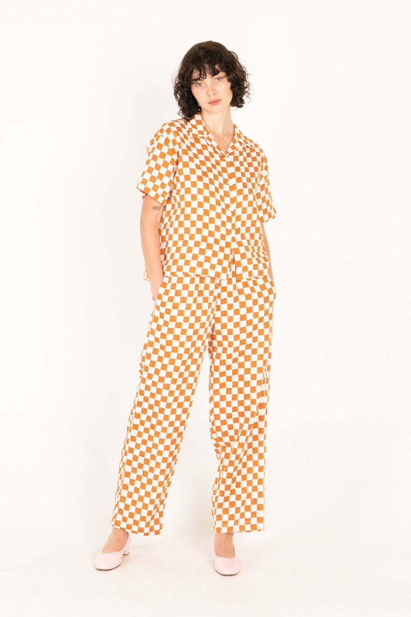 Person wearing an orange and white checkered outfit on a white background