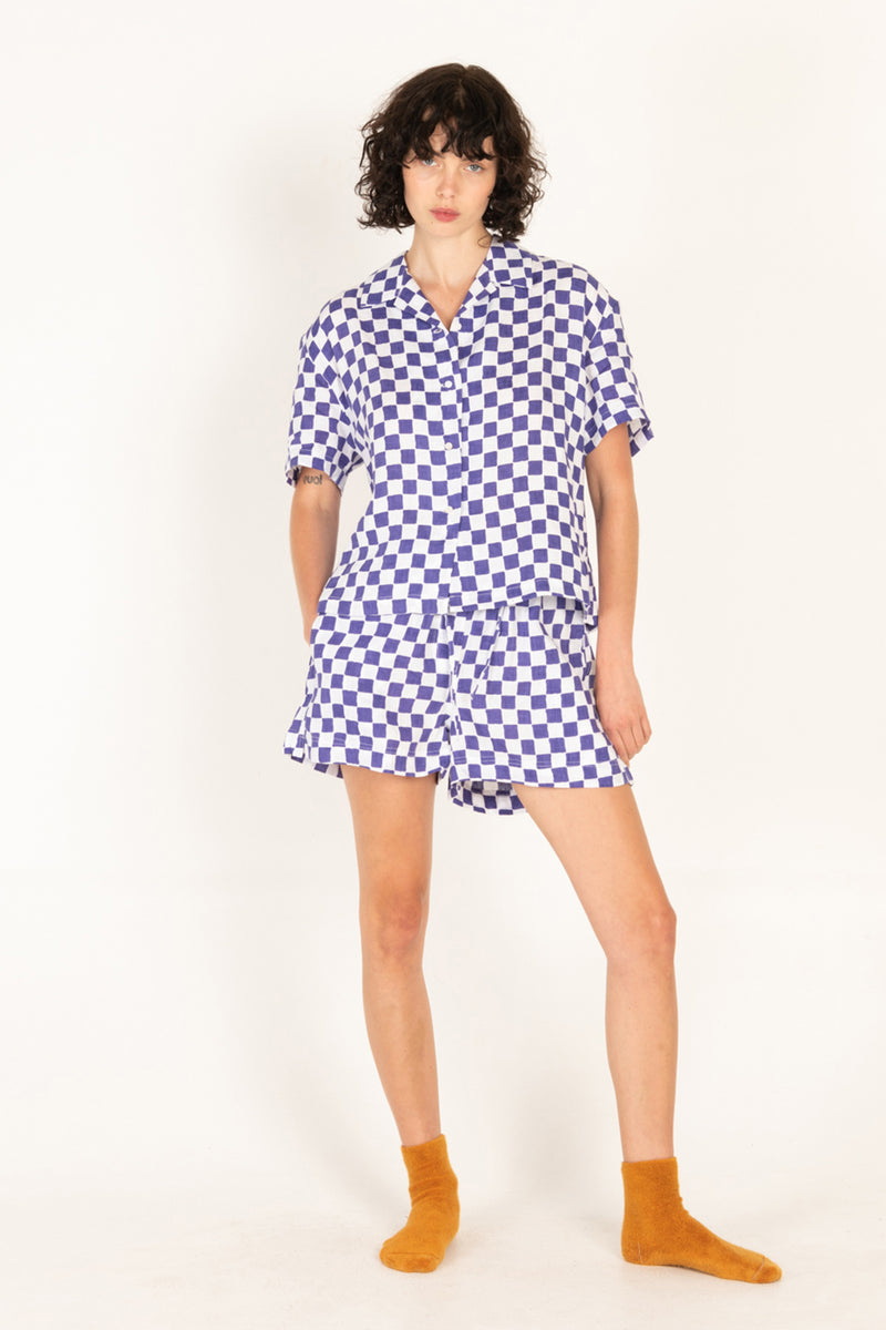 Woman wearing a blue and white checkered dress on a white background