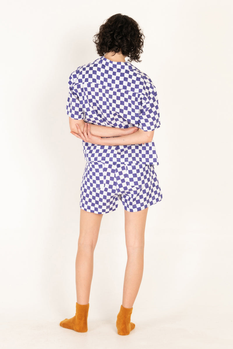Person wearing a blue and white checkered outfit on a white background