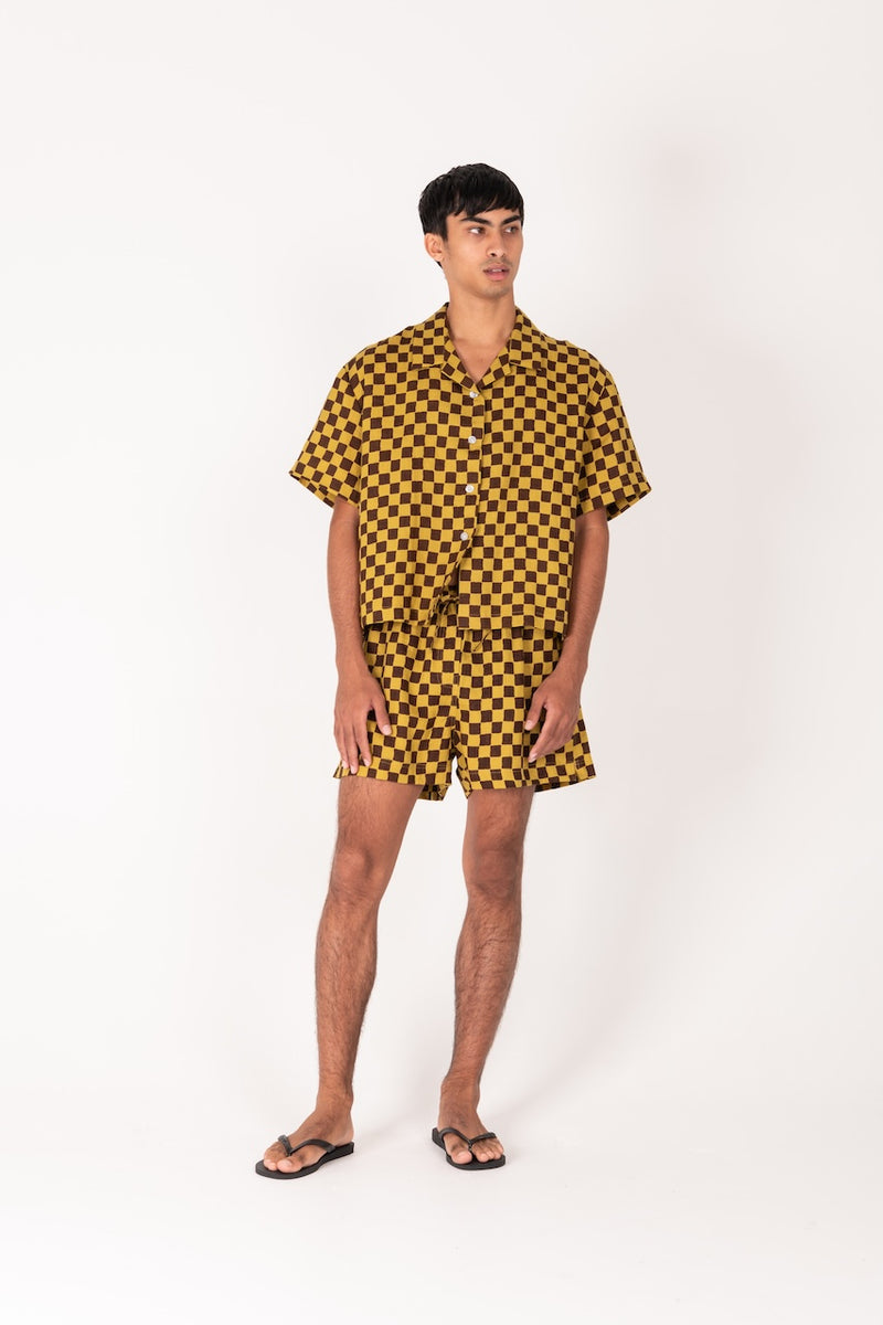 Person wearing a yellow and black checkered outfit on a white background