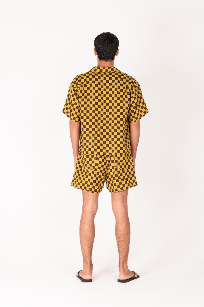 Person wearing a yellow and black checkered outfit on a white background