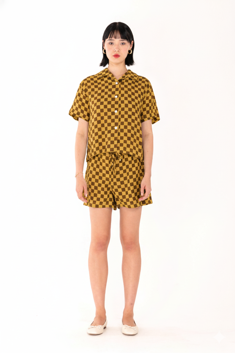 Woman wearing a yellow and black checkered outfit on a white background