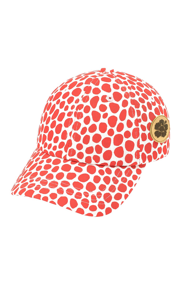 Red polka dot cap with a gold logo on a white background