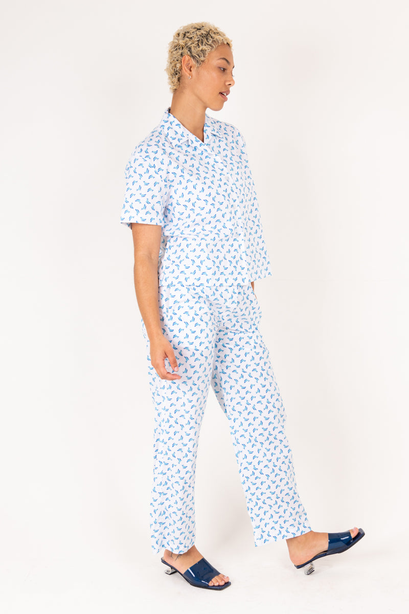 Woman wearing a blue patterned outfit on a white background