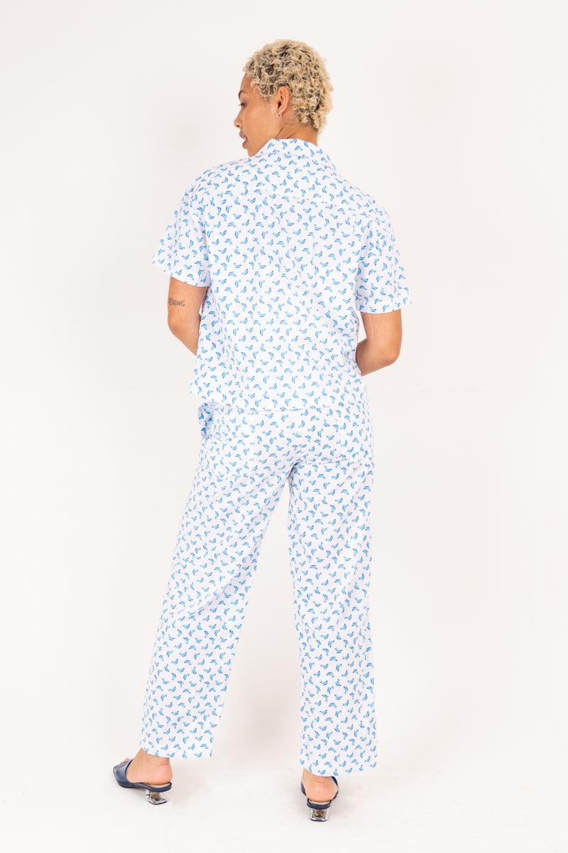 Person wearing a blue patterned outfit on a white background