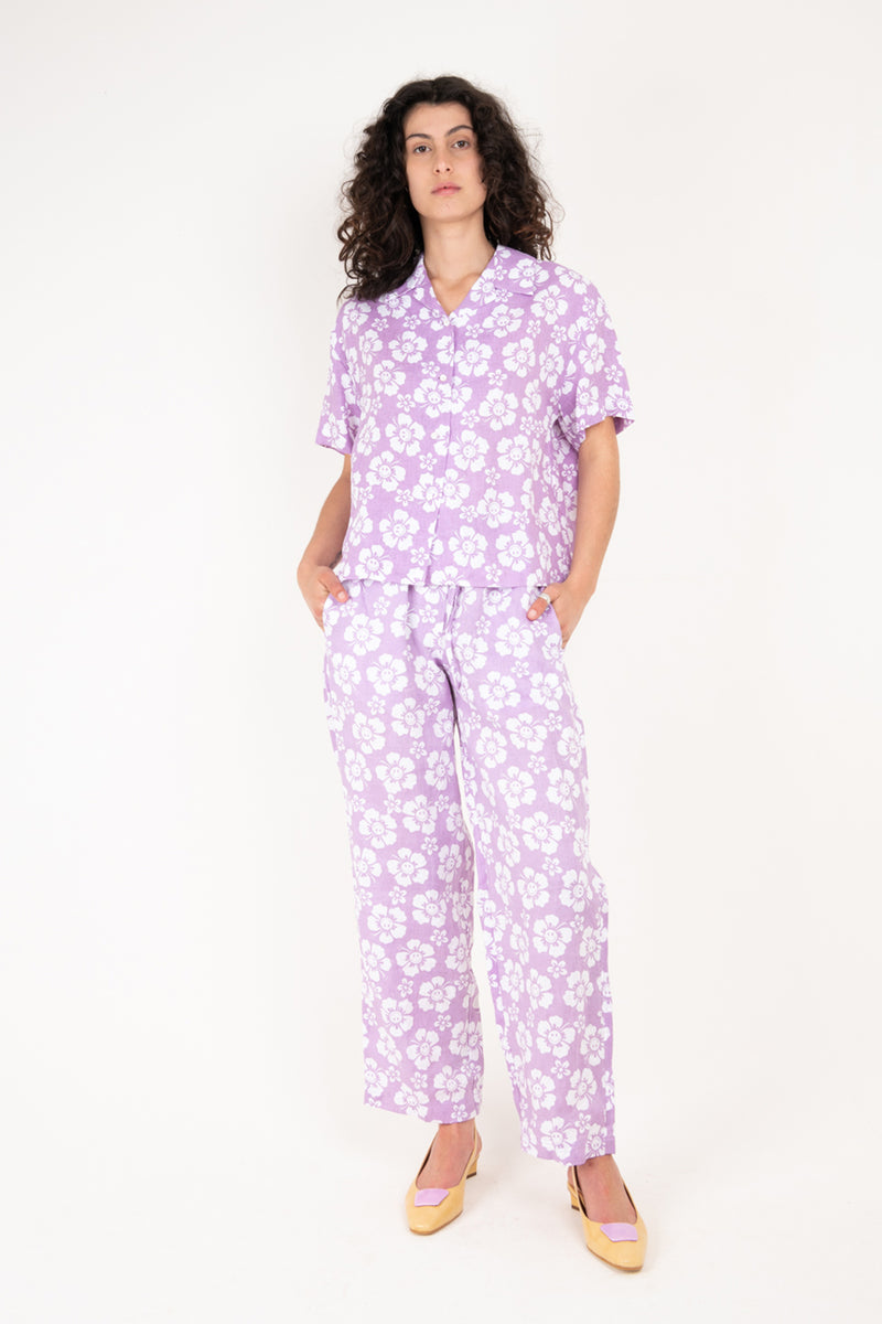 Woman wearing a purple floral pajama set on a white background