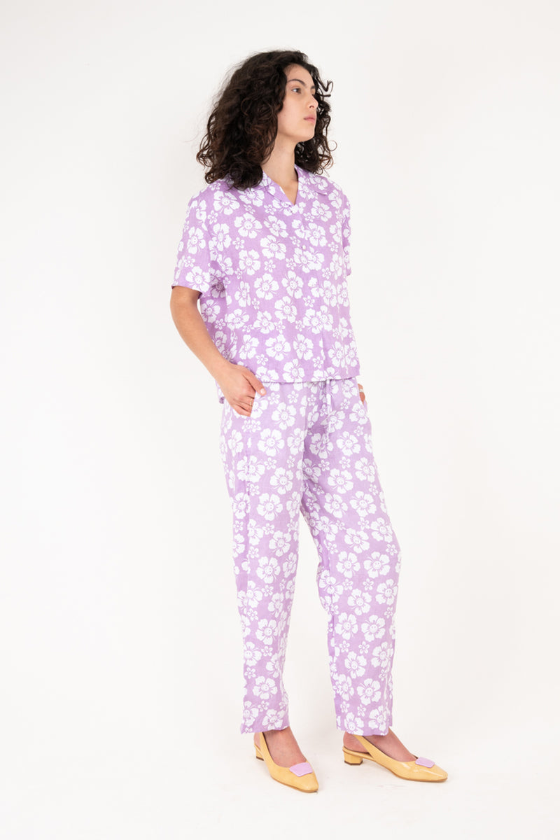 Woman wearing a purple floral pajama set on a white background