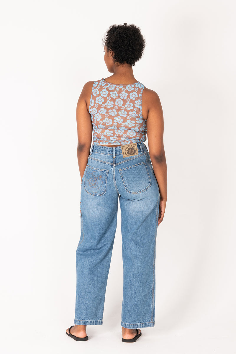 Person wearing a floral top and blue jeans on a white background