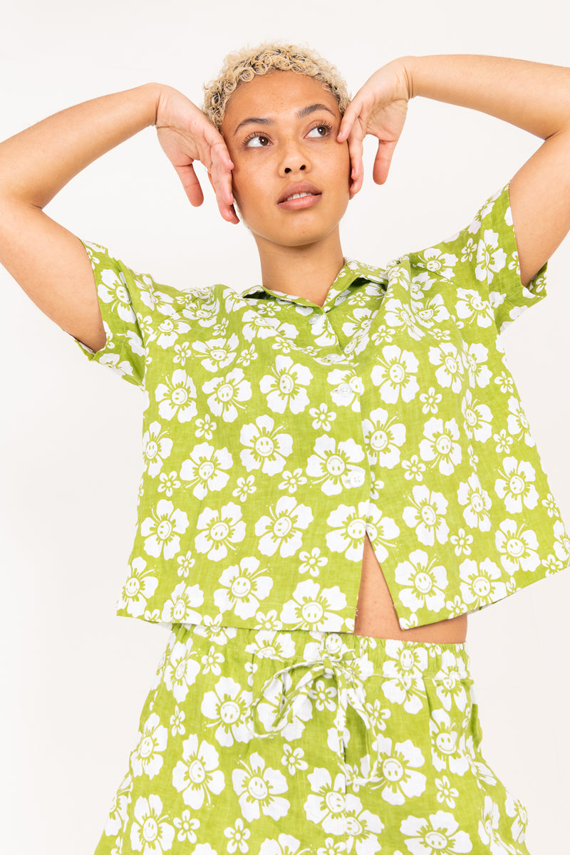 Woman wearing a green floral outfit against a white background