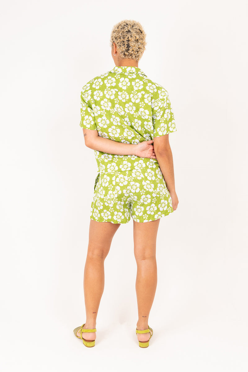 Woman wearing a green floral outfit on a white background