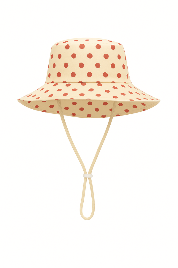 Beige bucket hat with red polka dots on a white background