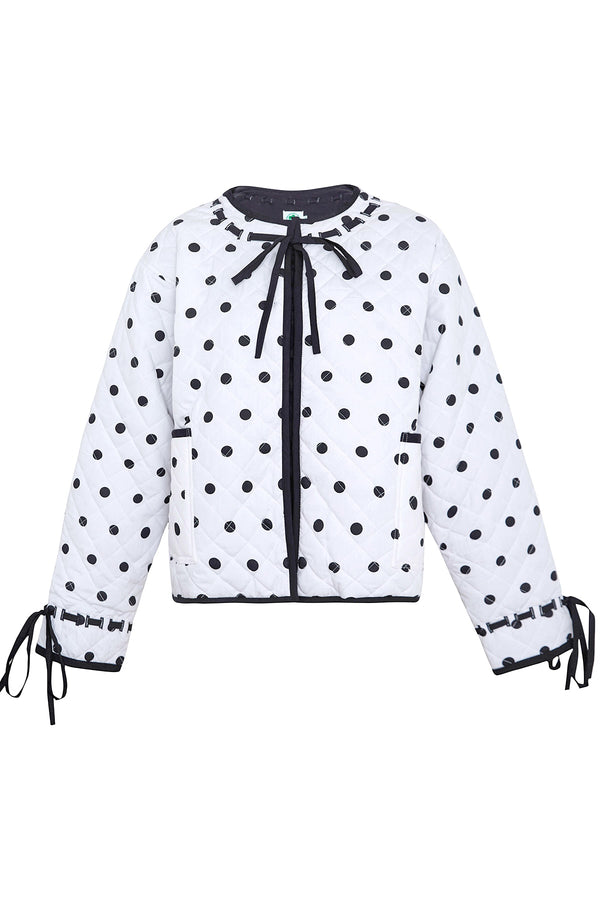 White blouse with black polka dots and a bow tie on a white background