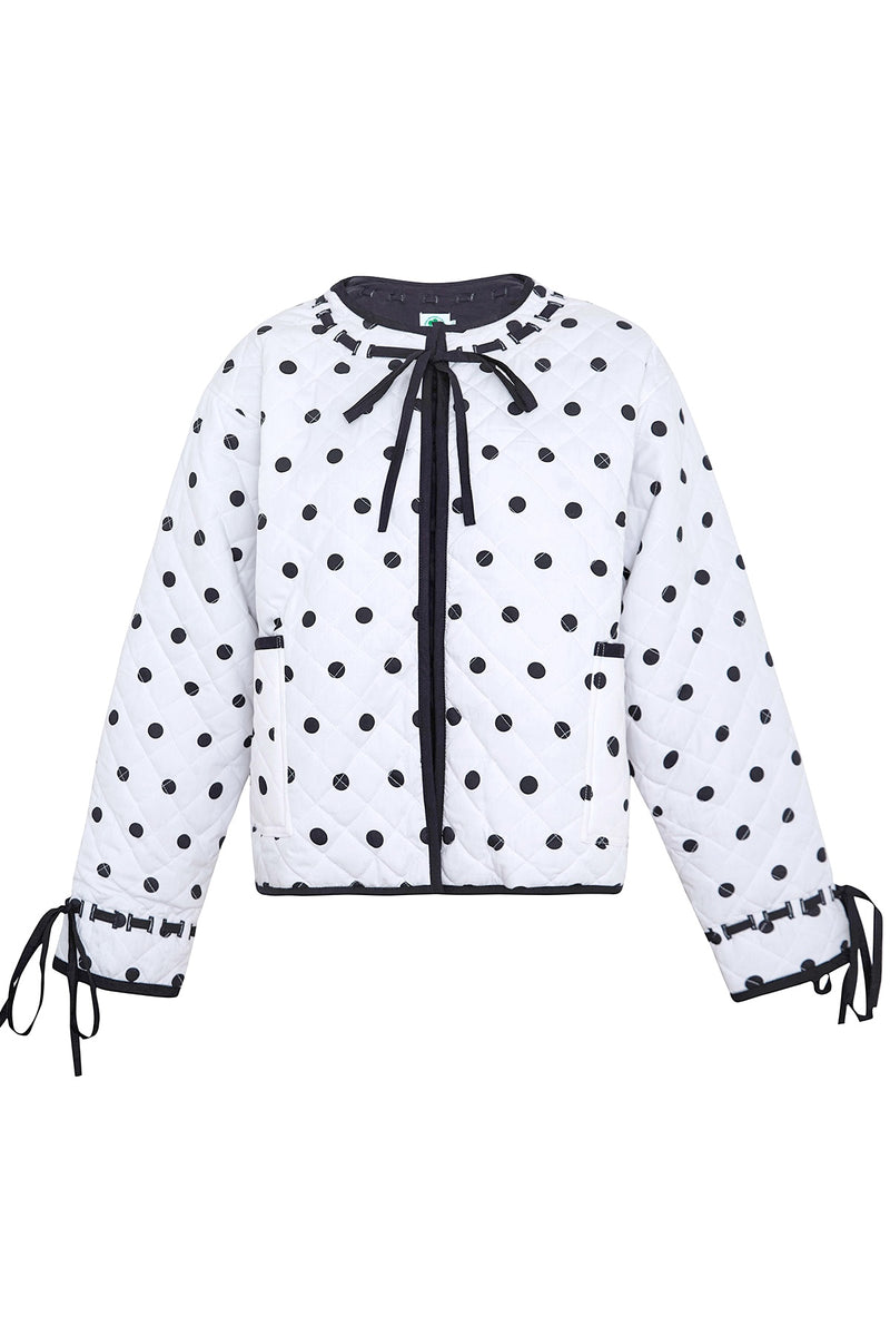 White blouse with black polka dots and a bow tie on a white background