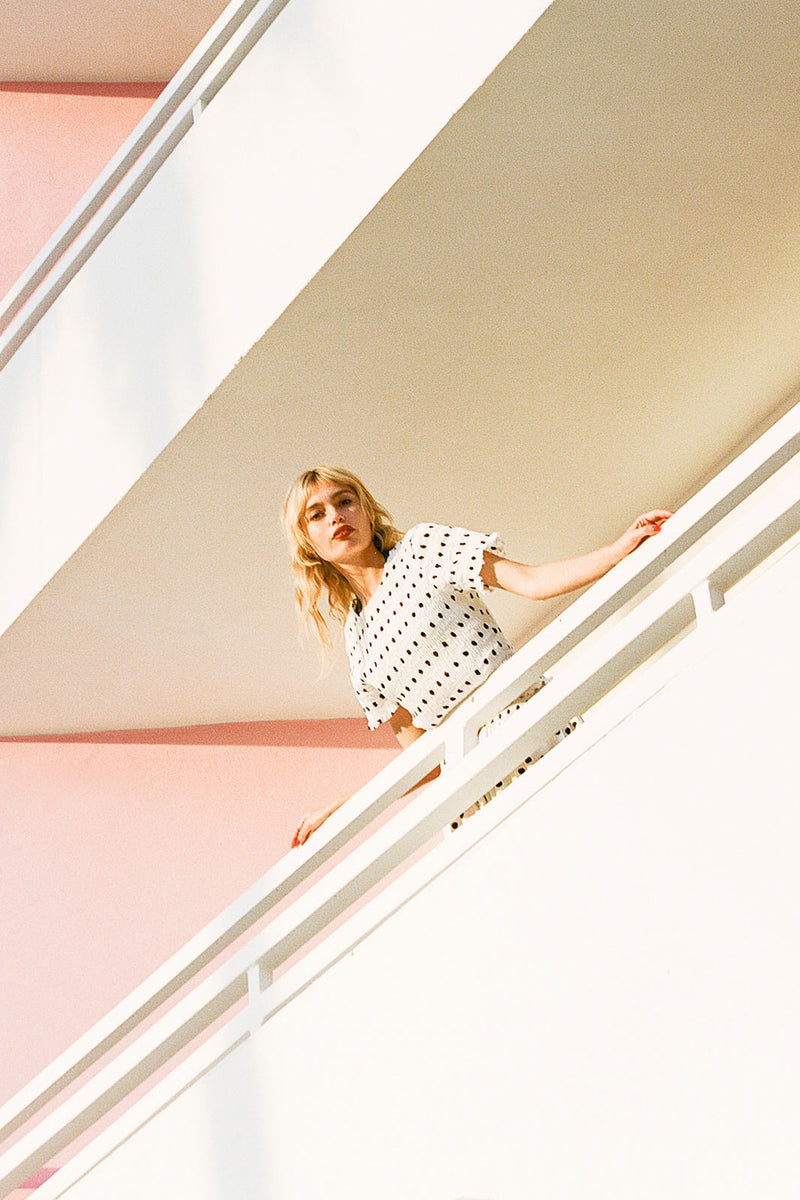 Woman standing on a staircase with a minimalistic background