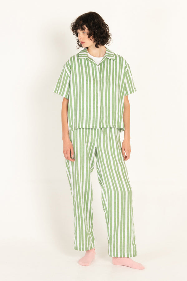 Person wearing green and white striped pajamas on a white background
