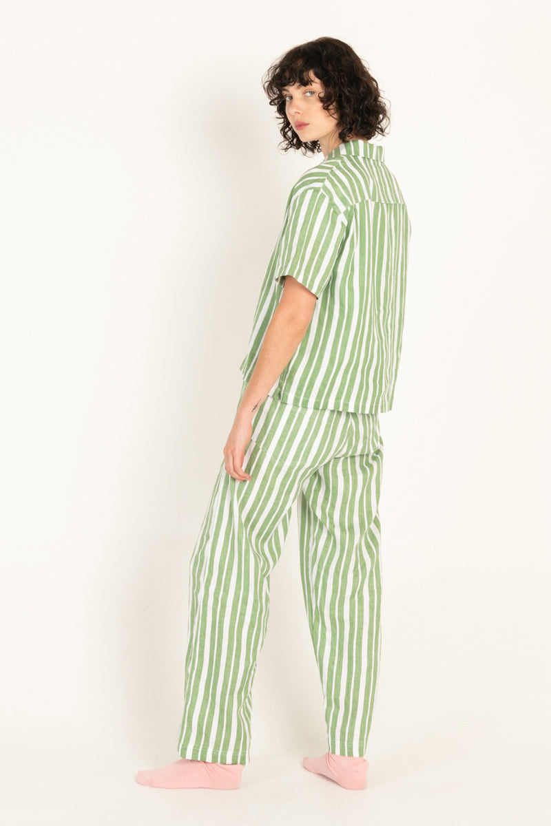 Person wearing green and white striped pajamas on a white background
