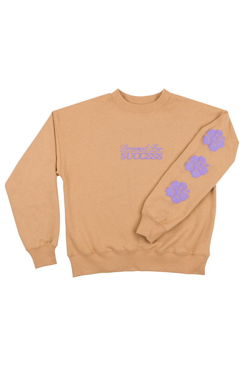 Beige sweatshirt with purple text and floral designs on a white background