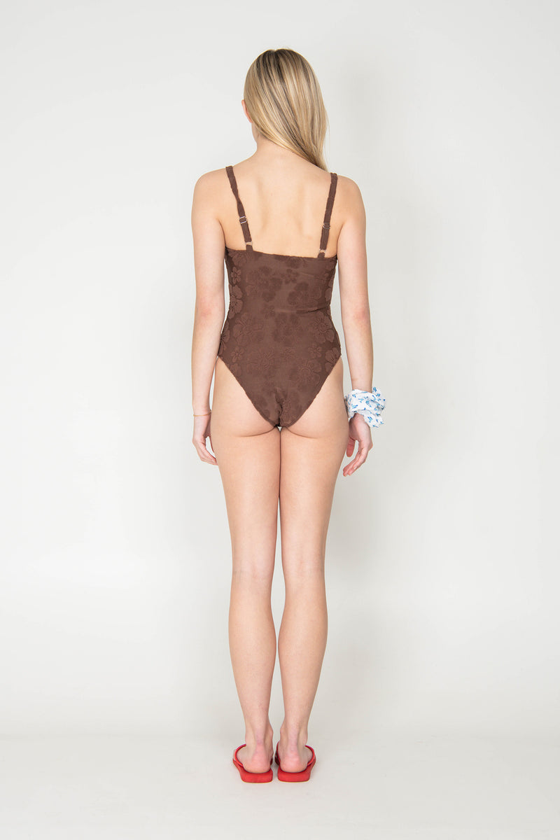 Woman wearing a brown swimsuit on a white background
